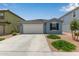 Inviting home with two-car garage, desert landscaping, and a well-maintained lawn at 36463 W San Alvarez Ave, Maricopa, AZ 85138