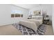Well-lit bedroom featuring a large window and a patterned rug under the bed at 37627 W Padilla St, Maricopa, AZ 85138