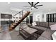 Bright living room featuring a gray sectional sofa, floating stairs, and modern decor at 4208 N Parkway Ave, Scottsdale, AZ 85251