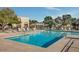 Large community swimming pool surrounded by lounge chairs, tables, and umbrellas on a sunny day at 4208 N Parkway Ave, Scottsdale, AZ 85251