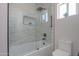 Bathroom with marble tile surround, walk-in shower, matte black fixtures, and a bright window at 43481 W Carefree Pl, Maricopa, AZ 85138