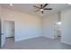 Spacious bedroom with a ceiling fan, wood-style tile flooring, and views to the ensuite bath at 43481 W Carefree Pl, Maricopa, AZ 85138