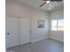 Bright bedroom with wood-look tile flooring, ceiling fan, closet, and natural light from window at 43481 W Carefree Pl, Maricopa, AZ 85138