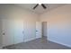 Bedroom featuring wood-look tile, closet, ceiling fan, and a doorway to another room at 43481 W Carefree Pl, Maricopa, AZ 85138