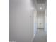Long hallway with wood-look tile and white walls leading to a room with double doors at 43481 W Carefree Pl, Maricopa, AZ 85138