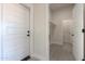 Entryway with white walls, doors, tile floor, and a glimpse into the laundry room at 43481 W Carefree Pl, Maricopa, AZ 85138