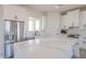 Bright kitchen with stainless steel appliances, large island, and white cabinetry at 43481 W Carefree Pl, Maricopa, AZ 85138