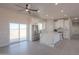 Open kitchen and living room with a large white island, stainless steel appliances, and abundant natural light at 43481 W Carefree Pl, Maricopa, AZ 85138