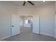 Open-concept living area showcasing wood-look tile and open door to a modern kitchen with island at 43481 W Carefree Pl, Maricopa, AZ 85138