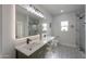 Modern bathroom with double vanity, decorative tile floor, and glass-enclosed shower at 43481 W Carefree Pl, Maricopa, AZ 85138