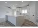 Bright kitchen featuring white cabinets, quartz countertops, a spacious island and modern finishes at 43481 W Carefree Pl, Maricopa, AZ 85138