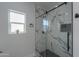 Stylish bathroom with a glass shower featuring marble-like tiles and black hardware at 43481 W Carefree Pl, Maricopa, AZ 85138