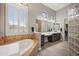 Luxurious bathroom with a soaking tub, dual vanity, and glass block shower feature at 4684 E Coachwhip Rd, Cave Creek, AZ 85331