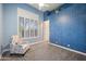 Serene bedroom with blue walls, plantation shutters, and a cozy patterned armchair at 4684 E Coachwhip Rd, Cave Creek, AZ 85331