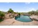 Backyard pool with stone waterfall and slide, surrounded by mature desert landscaping at 4684 E Coachwhip Rd, Cave Creek, AZ 85331