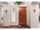 Inviting entryway featuring a solid wood front door, neutral paint, and beautiful wood floors at 5509 E Desert Hills Dr, Scottsdale, AZ 85254