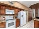 Well-equipped kitchen features wood cabinets, granite countertops, and white appliances at 5509 E Desert Hills Dr, Scottsdale, AZ 85254