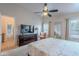 This well-lit bedroom includes a ceiling fan, dresser, and view to the adjoining bathroom at 650 N Hawes Rd # 4128, Mesa, AZ 85207