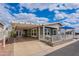 Charming single-story home featuring a covered porch, carport, and nicely landscaped front yard with a seating area at 650 N Hawes Rd # 4128, Mesa, AZ 85207