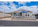 Charming single-story home featuring a covered porch, carport, and nicely landscaped front yard with a seating area at 650 N Hawes Rd # 4128, Mesa, AZ 85207