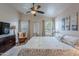 Bright main bedroom with a ceiling fan, carpet floors, natural lighting, and stylish decor at 650 N Hawes Rd # 4128, Mesa, AZ 85207