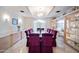 Elegant dining room with a large table, purple chairs, marble flooring, glass display cases, and a decorative chandelier at 6997 E Paradise Ranch Rd, Paradise Valley, AZ 85253