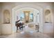 Elegant living room with a fireplace, grand piano, and arched doorways at 6997 E Paradise Ranch Rd, Paradise Valley, AZ 85253