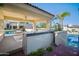 A luxurious outdoor kitchen, complete with a sink, grill, and ample counter space for entertaining by the pool at 6997 E Paradise Ranch Rd, Paradise Valley, AZ 85253