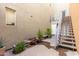 Exterior shot featuring a wooden staircase, potted plants, bench seating, and a textured neutral wall at 706 E Washington St # 207, Phoenix, AZ 85034