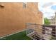 A view from the balcony showing a brown textured wall with artificial grass at 706 E Washington St # 207, Phoenix, AZ 85034
