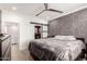 A primary bedroom with a ceiling fan, closet, barn door and grey accent wall at 706 E Washington St # 207, Phoenix, AZ 85034