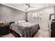 A primary bedroom featuring a ceiling fan, window with plantation shutters and grey accent wall at 706 E Washington St # 207, Phoenix, AZ 85034