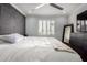 Bedroom with a ceiling fan, accent wall, and white plantation shutters on the window at 706 E Washington St # 207, Phoenix, AZ 85034