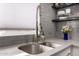 Close-up of the kitchen sink featuring modern fixtures, stylish backsplash and grey countertops at 706 E Washington St # 207, Phoenix, AZ 85034