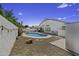 A backyard showcases a private pool and patio area surrounded by greenery and gravel landscaping at 7832 E Osage Ave, Mesa, AZ 85212