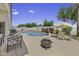 An inviting backyard pool and patio area offers a relaxing oasis with seating and well-manicured plants at 7832 E Osage Ave, Mesa, AZ 85212