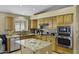 Kitchen featuring stainless steel appliances, an island with granite countertops, and warm wood cabinetry at 7832 E Osage Ave, Mesa, AZ 85212