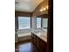 Bathroom featuring dual sinks, tub, and a glass block window for natural light and privacy at 830 E Dry Creek Rd, San Tan Valley, AZ 85143