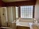 Bright bathroom with a glass block window, separate shower, soaking tub, and single vanity at 830 E Dry Creek Rd, San Tan Valley, AZ 85143