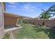 A grassy backyard with a covered patio and block wall, perfect for entertaining at 8745 W Windsor Dr, Peoria, AZ 85381