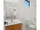 Bright bathroom with a sink and vanity, toilet, and a window that allows natural light in at 8745 W Windsor Dr, Peoria, AZ 85381