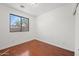 Clean, empty bedroom with hardwood floors and a window overlooking a palm tree at 8745 W Windsor Dr, Peoria, AZ 85381