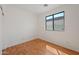 A clean, empty bedroom with hardwood floors and a window to let natural light in at 8745 W Windsor Dr, Peoria, AZ 85381