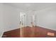 Empty bedroom with hardwood flooring, white walls, and a doorway to an ensuite bathroom at 8745 W Windsor Dr, Peoria, AZ 85381