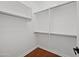 Walk-in closet with hardwood floors and white shelving with chrome bars for hanging clothes at 8745 W Windsor Dr, Peoria, AZ 85381