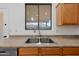 Bright kitchen area featuring a stainless steel sink and light wood cabinets at 8745 W Windsor Dr, Peoria, AZ 85381