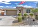 Charming single-story home featuring desert landscaping, stone accents, and an American flag in the front yard at 9343 W Atlantis Way, Tolleson, AZ 85353