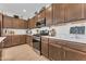 Well-appointed kitchen with stainless appliances, quartz countertops, and ample cabinet space for culinary enthusiasts at 9343 W Atlantis Way, Tolleson, AZ 85353