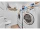 Functional laundry room with washer, dryer, and storage shelves for convenience at 9343 W Atlantis Way, Tolleson, AZ 85353