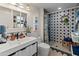 Charming bathroom featuring a patterned tile shower, white vanity, and colorful decor at 11119 W Mountain View Rd, Sun City, AZ 85351